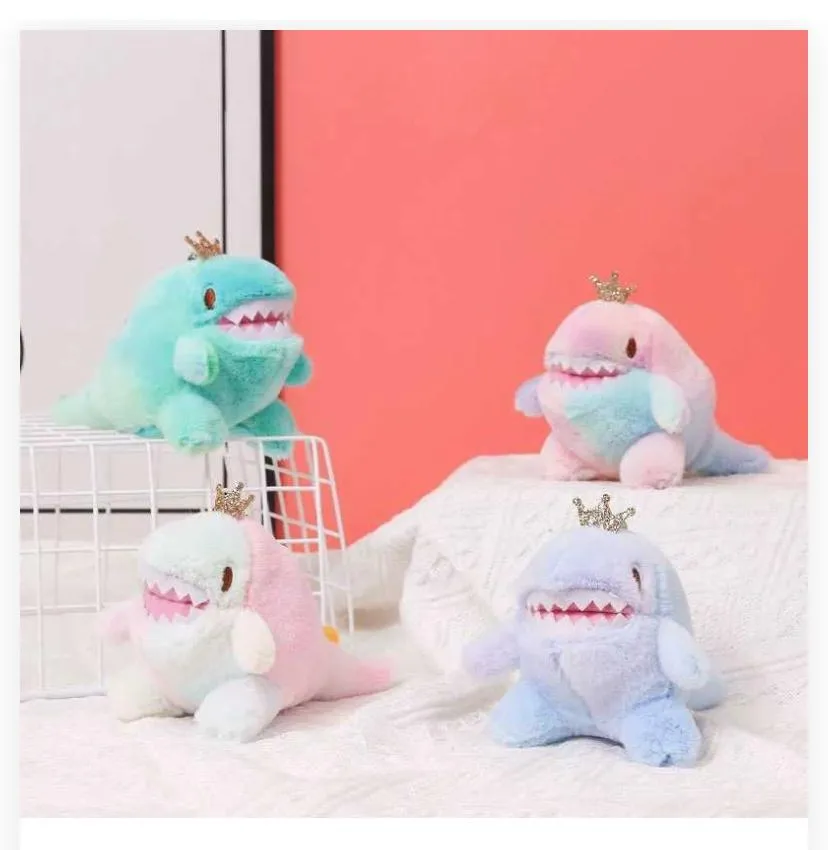 crown-wearing dinosaur/monster plushies displayed in a two-tiered arrangement against a coral-pink wall and white textured fabric