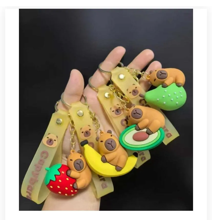 fruit-themed 3D capybara keychains displayed in hand.
