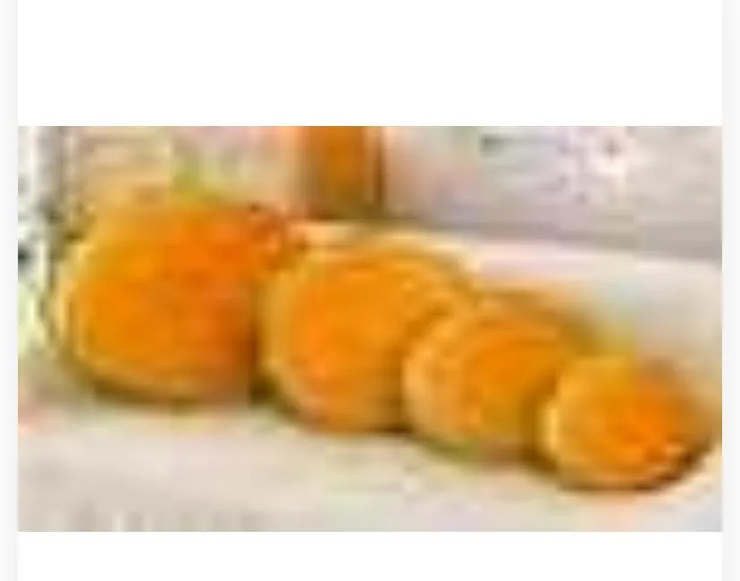 yellow-orange plush cushions lined up in descending size order on a white surface.
