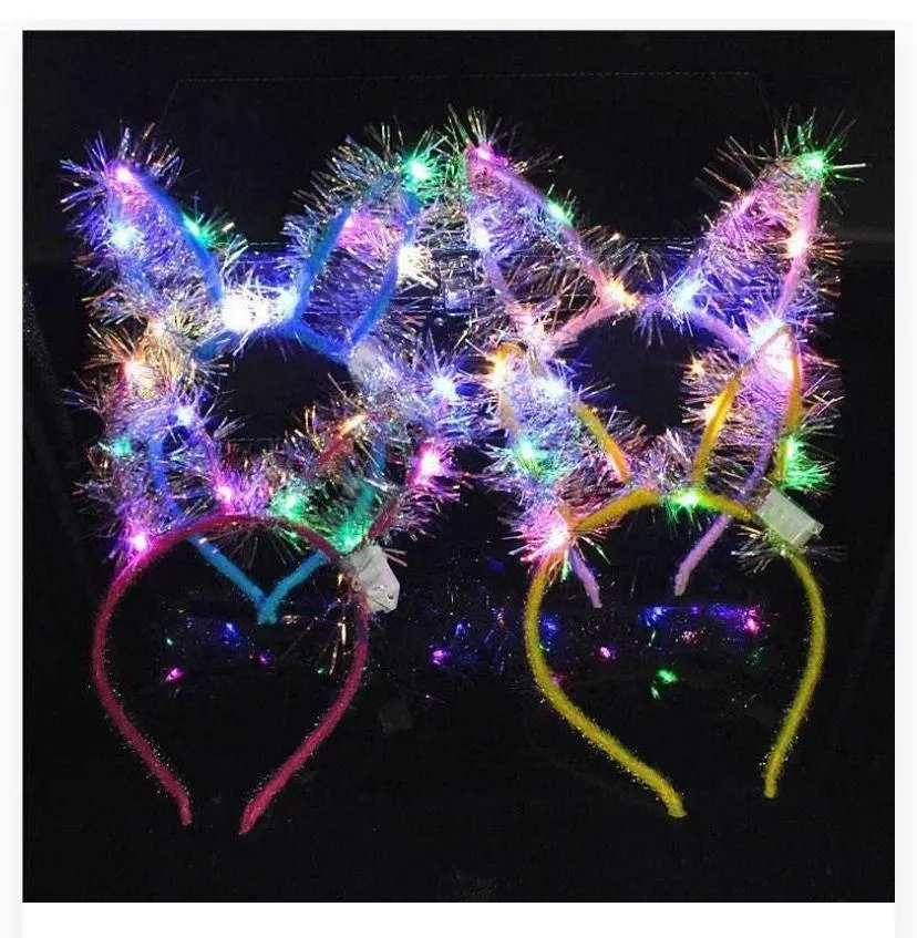 Features glittery/sparkling tinsel bunny ears framed with bright, integrated LED lights, mounted on flexible, textured headbands.