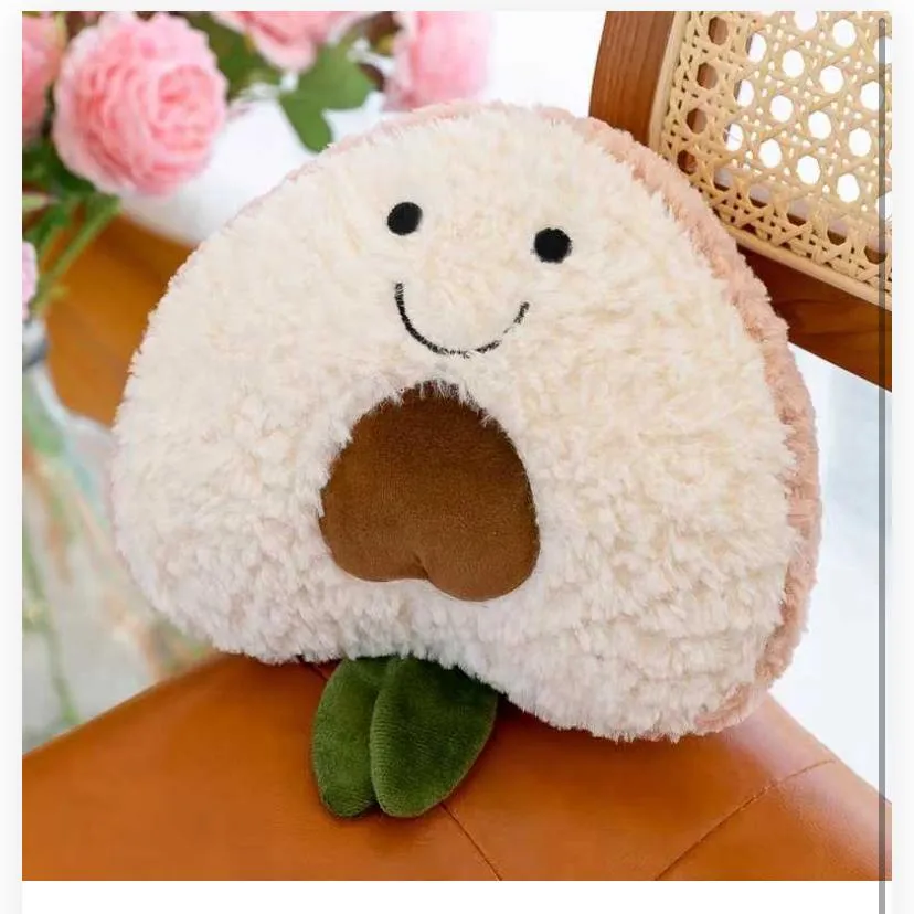 avocado-shaped plush throw pillow resting on a brown leather chair, styled in a cozy indoor setting.